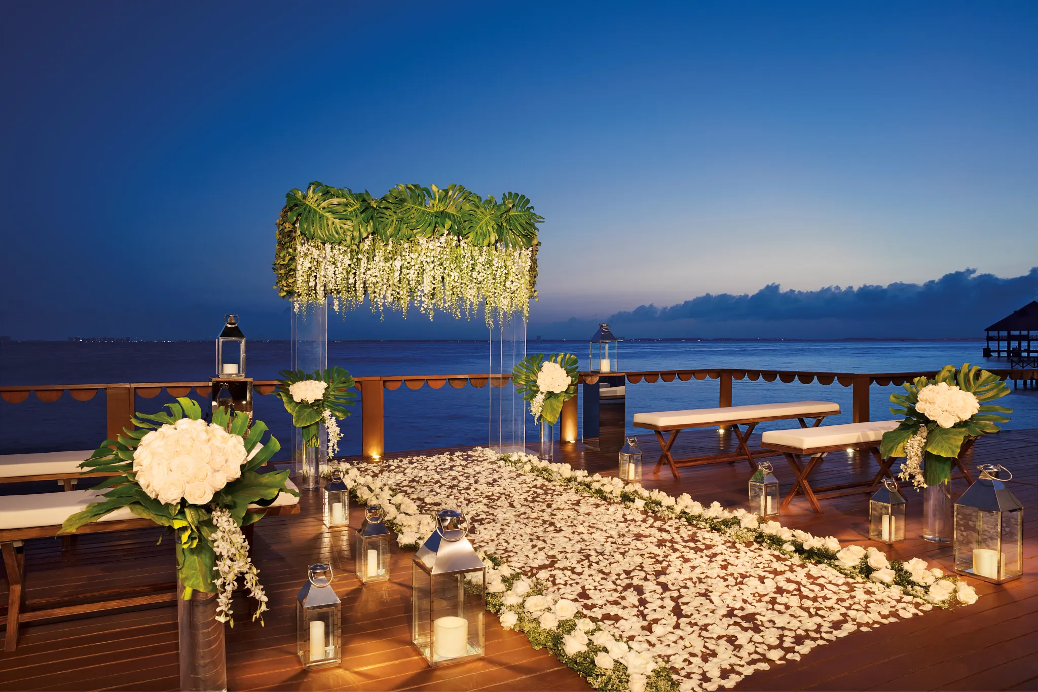 Oceanfront wooden deck wedding venue with pergola and palm trees at Zoëtry Villa Rolandi Isla Mujeres