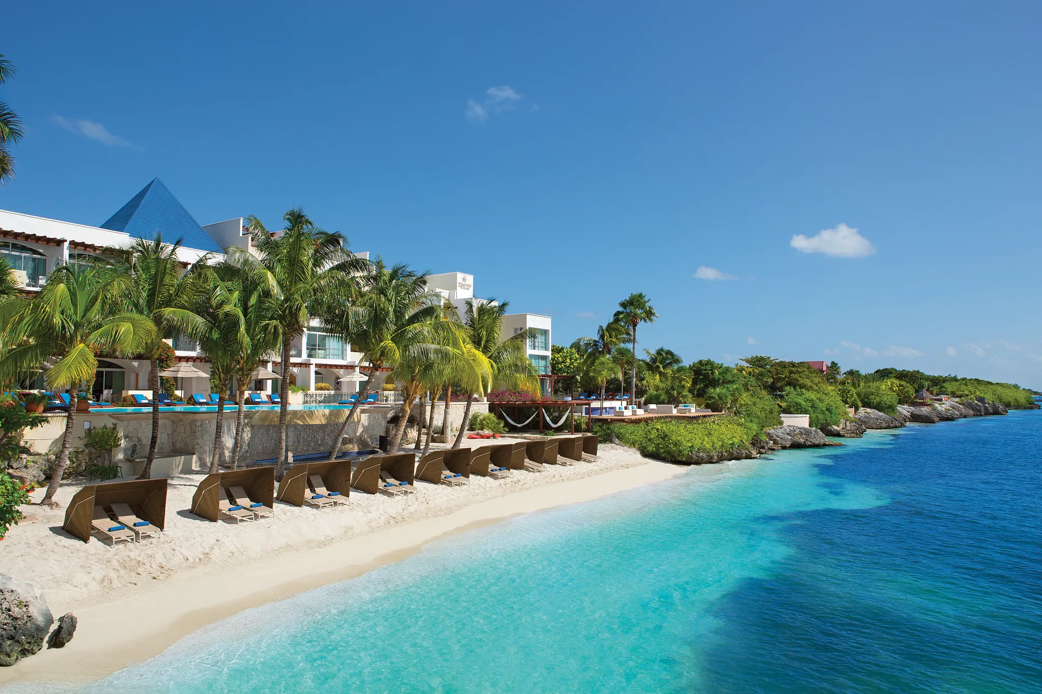 Private white sand beach with cabanas and turquoise water at Zoëtry Villa Rolandi Isla Mujeres.