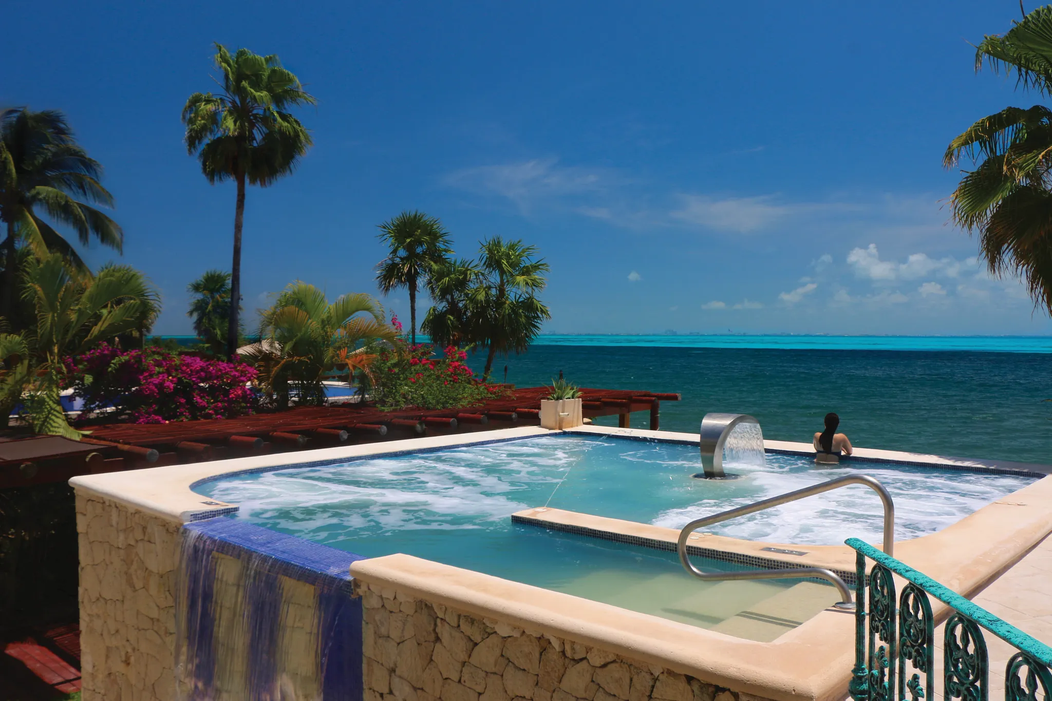 Outdoor oceanfront whirlpool spa with cascading water feature at Zoëtry Villa Rolandi Isla Mujeres.